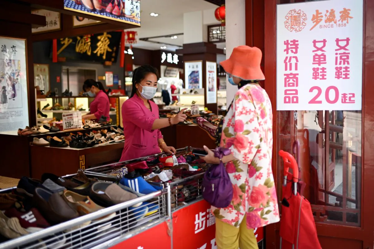 A shopper chooses shoes that cost 20 yuan ($2.86) per pair in Beijing on June 30, 2020. (Wang Zhao/AFP via Getty Images)