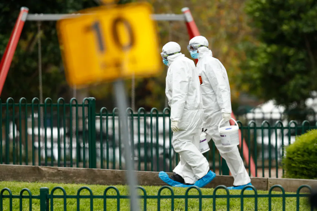 Workers in personal protective equipment are seen entering the Flemington Towers Government Housing complex on July 06, 2020 in Melbourne, Australia. (Darrian Traynor/Getty Images)