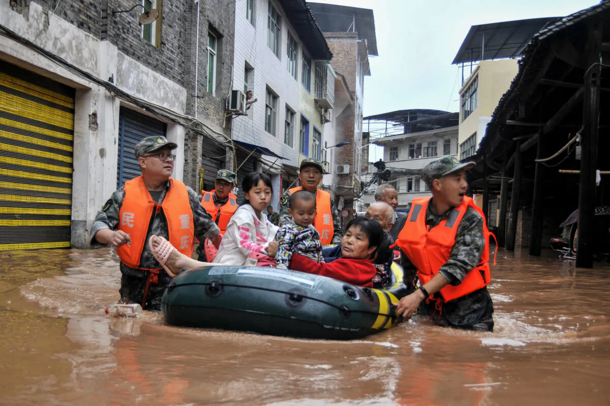 This photo taken on June 28, 2020 shows rescuers evacuating residents in a flooded area after heavy rain in China's southwestern Chongqing. (STR/AFP via Getty Images)