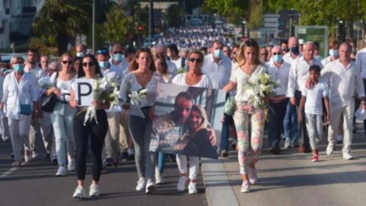 Veronique Monguillot (C), wife of bus driver Philippe Monguillot who was declared brain-dead after being attacked for refusing to let aboard a group of people who were not wearing face masks, holds a picture of her husband during a white march in Bayonne, southwestern France, on July 8, 2020. (Iroz Gaizka/AFP via Getty Images)