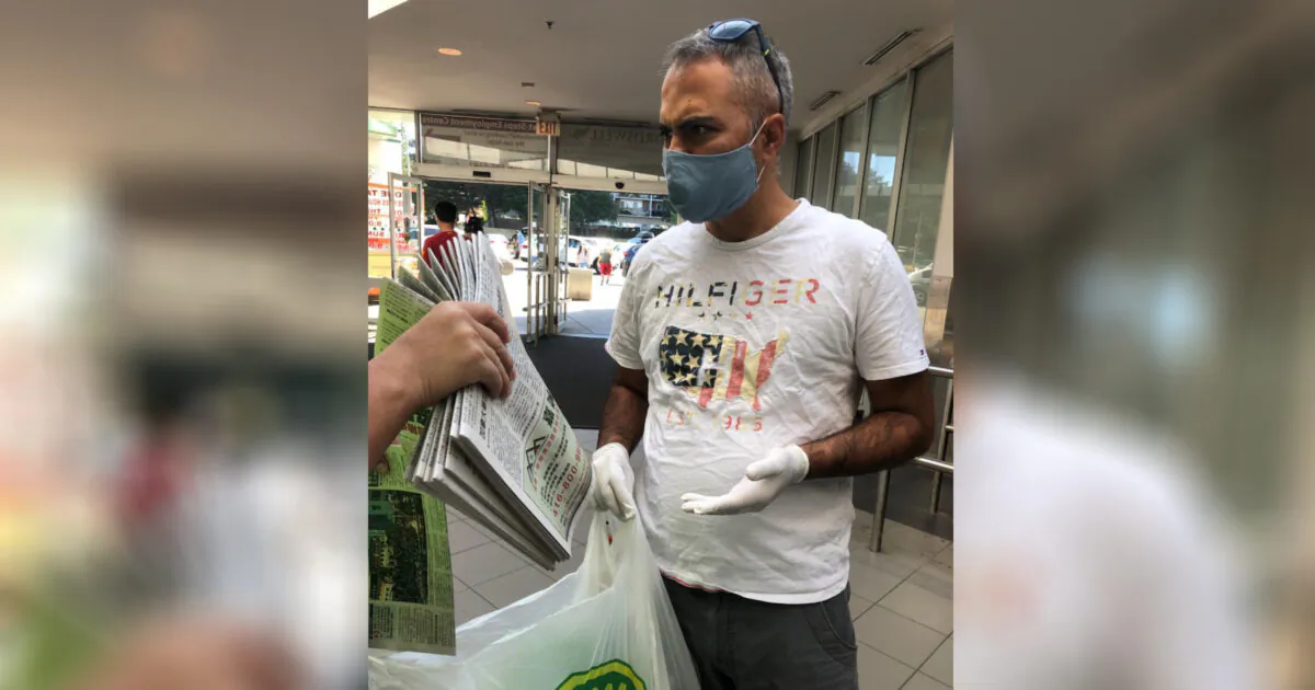 A man is confronted by an Epoch Times staff member (not seen in frame) after he was spotted taking more than 10 copies of The Epoch Times newspaper from a location in Toronto on July 4, 2020. (The Epoch Times)