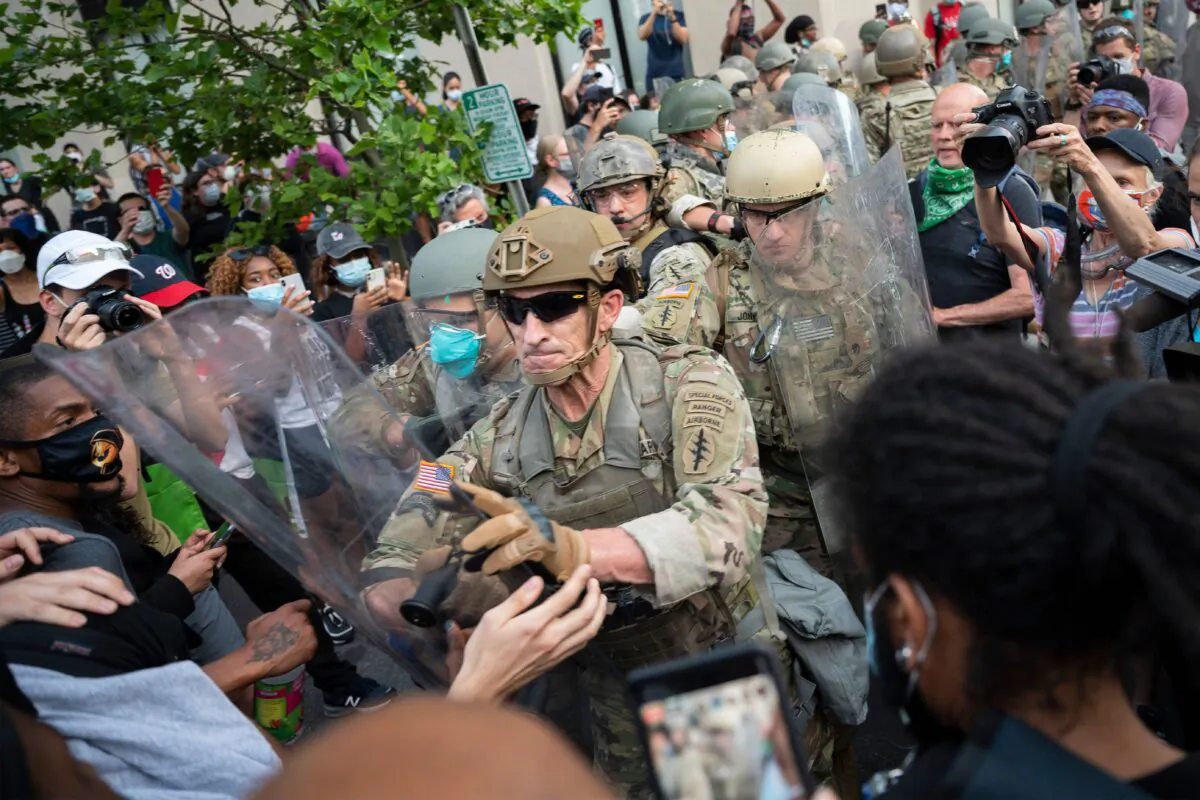 Protesters scuffle with members of the US Army as they demonstrate the death of George Floyd near the White House in Washington on June 3, 2020. (Jim Watson//AFP via Getty Images)