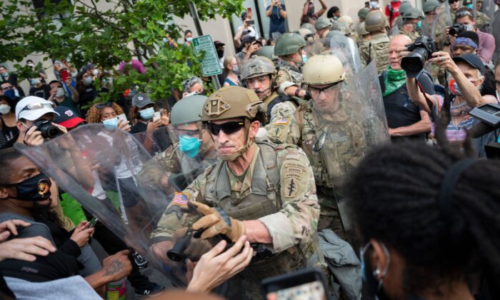 Protesters scuffle with members of the US Army as they demonstrate the death of George Floyd near the White House in Washington on June 3, 2020. (Jim Watson//AFP via Getty Images)