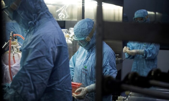 Researchers in protective suits work at a biopharmaceutical lab in Shenyang city, Liaoning Province, China, on June 9, 2020. (NOEL CELIS/AFP via Getty Images)