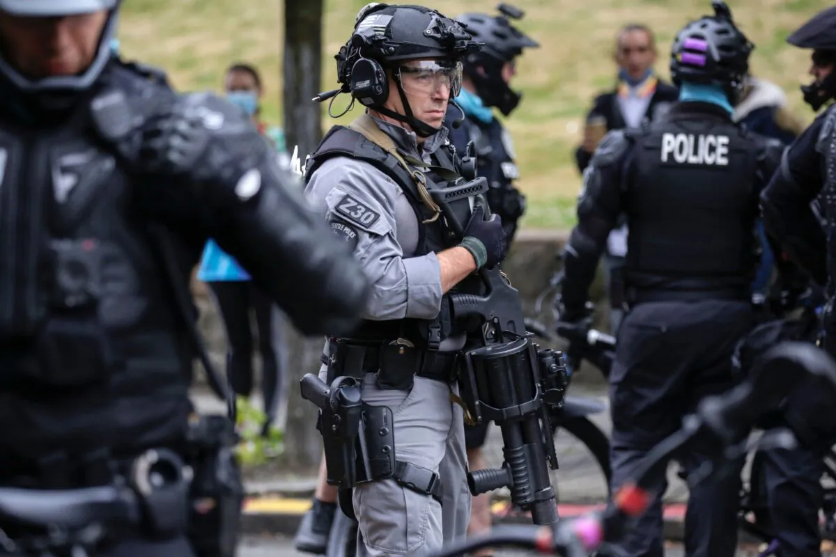 A Seattle Police officer stands watch as several people are arrested near the recently-cleared, so-called autonomous zone in Seattle, on July 1, 2020. (Jason Redmond/AFP via Getty Images)
