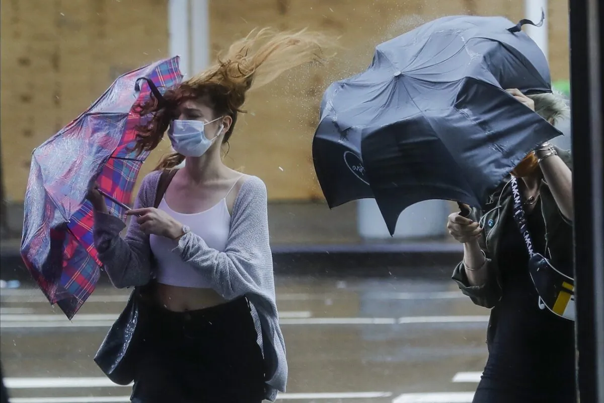Pedestrians struggle to control their umbrellas due to inclement weather brought about by Tropical Storm-turned-Depression Fay, in New York, on July 10, 2020. (AP Photo/Frank Franklin II)