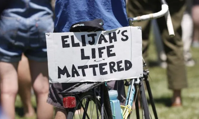 A placard is displayed on a bicycle during a rally and march over the death of 23-year-old Elijah McClain, Saturday, June 27, 2020, outside the police department in Aurora, Colo. McClain died in late August 2019, after he was stopped while walking to his apartment by three Aurora Police Department officers. (AP Photo/David Zalubowski)
