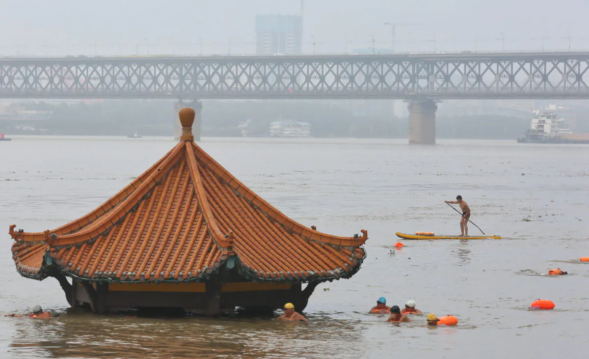 People swim near a pavilion partially submerged in floodwaters on the banks of the Yangtze River, following heavy rainfall in Wuhan, Hubei province, China July 8, 2020. (China Daily via Reuters)