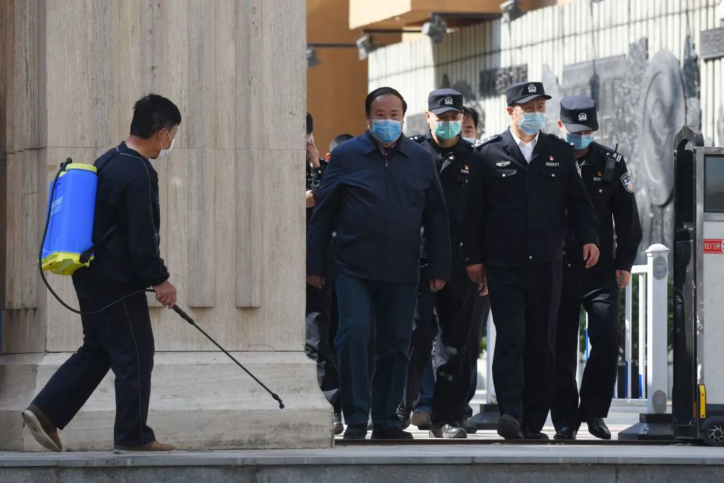 Police and officials emerge from a high school in Beijing, China, on April 27, 2020. (Greg Baker/AFP via Getty Images)