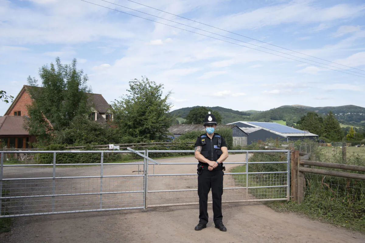 A police officer wearing a surgical face mask stands at the entrance to AS Green and Co farm in Mathon, Herefordshire, United Kingdom, on July 12, 2020. (Matthew Horwood/Getty Images)