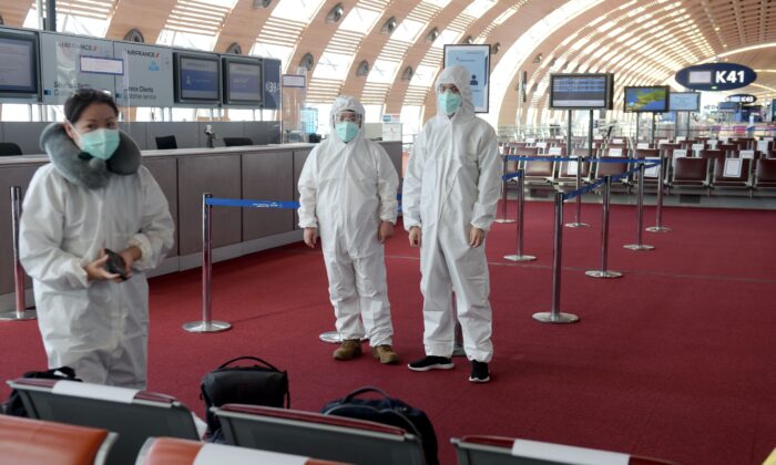 Passengers wearing protective clothing wait, prior to boarding a China Southern Airlines for Guangzhou at Charles de Gaulle Airport on the outskirts of Paris on May 12, 2020. (Eric Piermont / AFP via Getty Images)