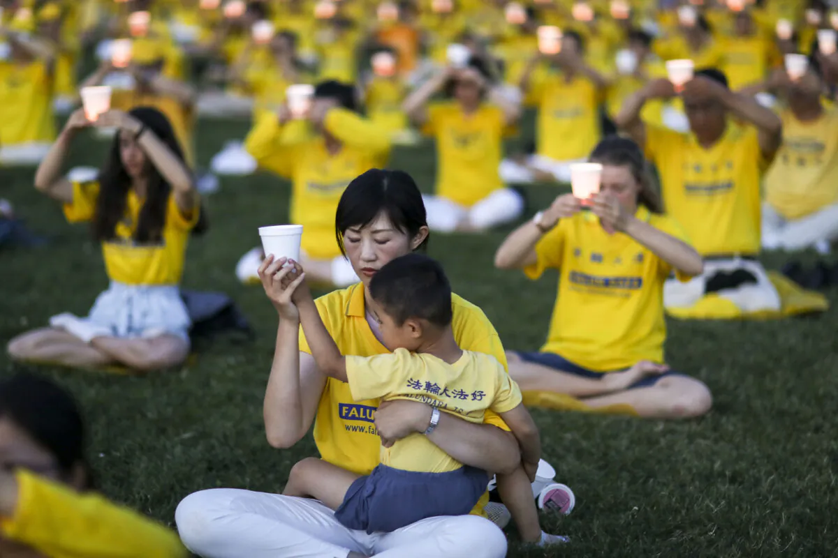 Falun Gong practitioners take part in a candlelight vigil commemorating the 20th anniversary of the start of the persecution of Falun Gong in China, on the West Lawn of Capitol Hill on July 18, 2019. (Samira Bouaou/The Epoch Times)