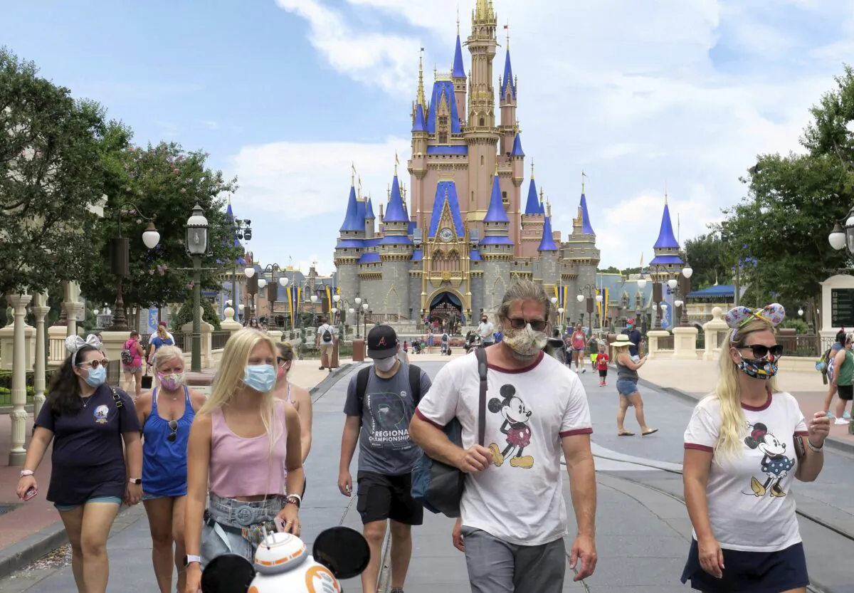 Guests wear masks as required to attend the official reopening day of the Magic Kingdom at Walt Disney World in Lake Buena Vista, Fla., on July 11, 2020. (Joe Burbank/Orlando Sentinel via AP)
