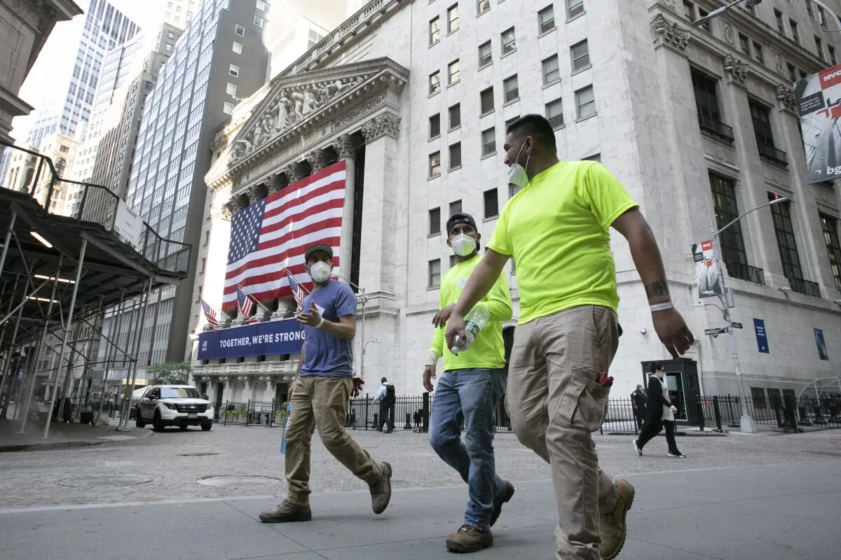 Workers wearing masks walk by the New York Stock Exchange in New York City on July 9, 2020. (Mark Lennihan/AP Photo)