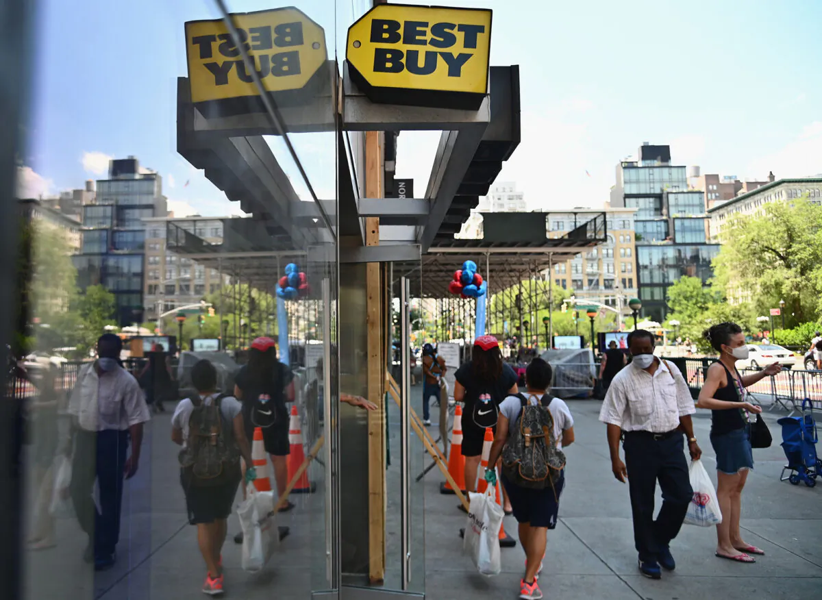 People wearing masks walk past a Best Buy store near Union Square in New York City, on June 25, 2020. (Angela Weiss/AFP via Getty Images)