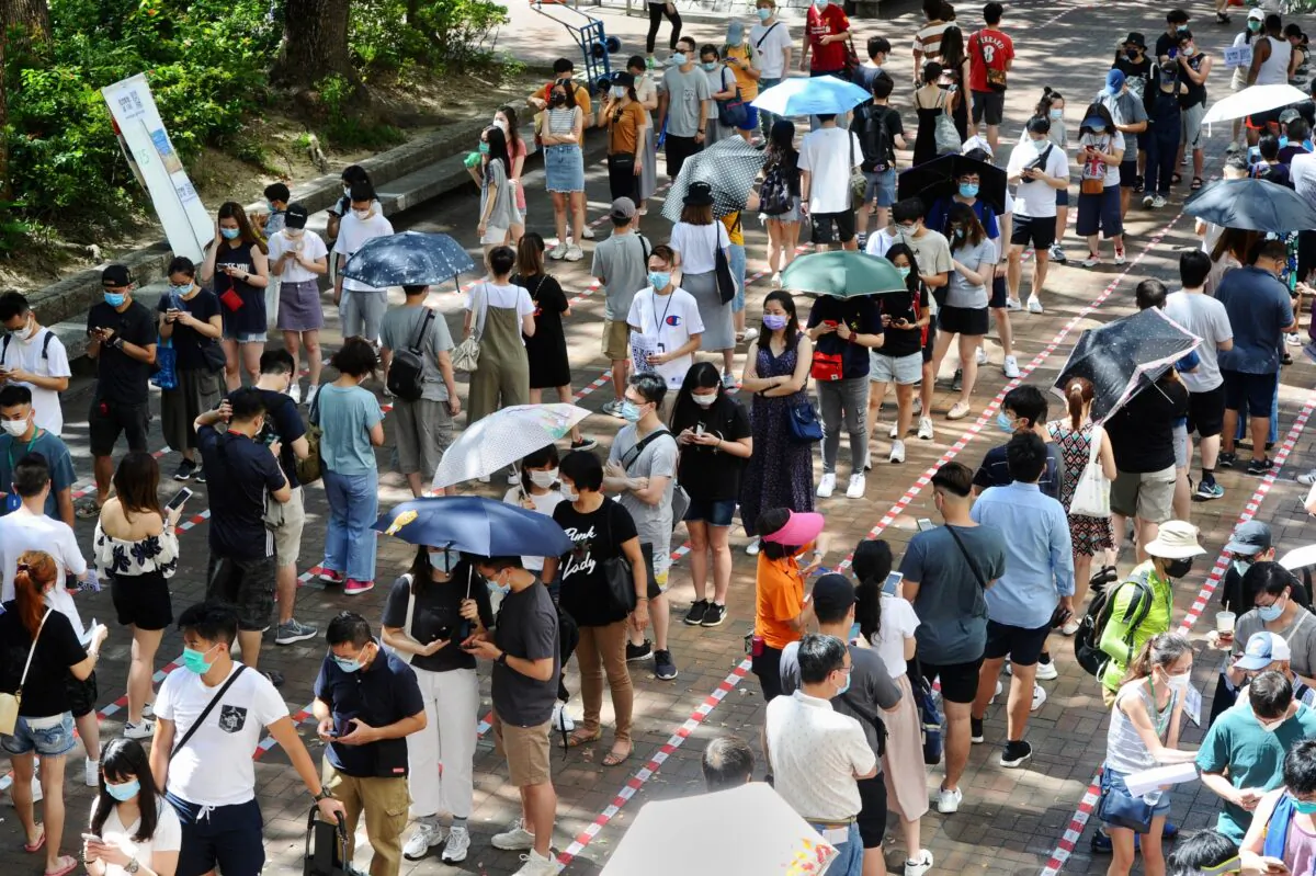 Voters queue up in long lines waiting to cast their votes in primary elections in Hong Kong, on July 12, 2020. (Song Bilung/The Epoch Times)