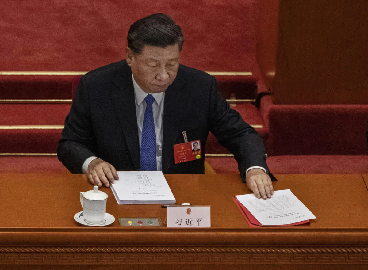 Chinese leader Xi Jinping arranges his papers at the closing session of the regime’s rubber stamp legislature Congress in Beijing, China on May 28, 2020. (Kevin Frayer/Getty Images)