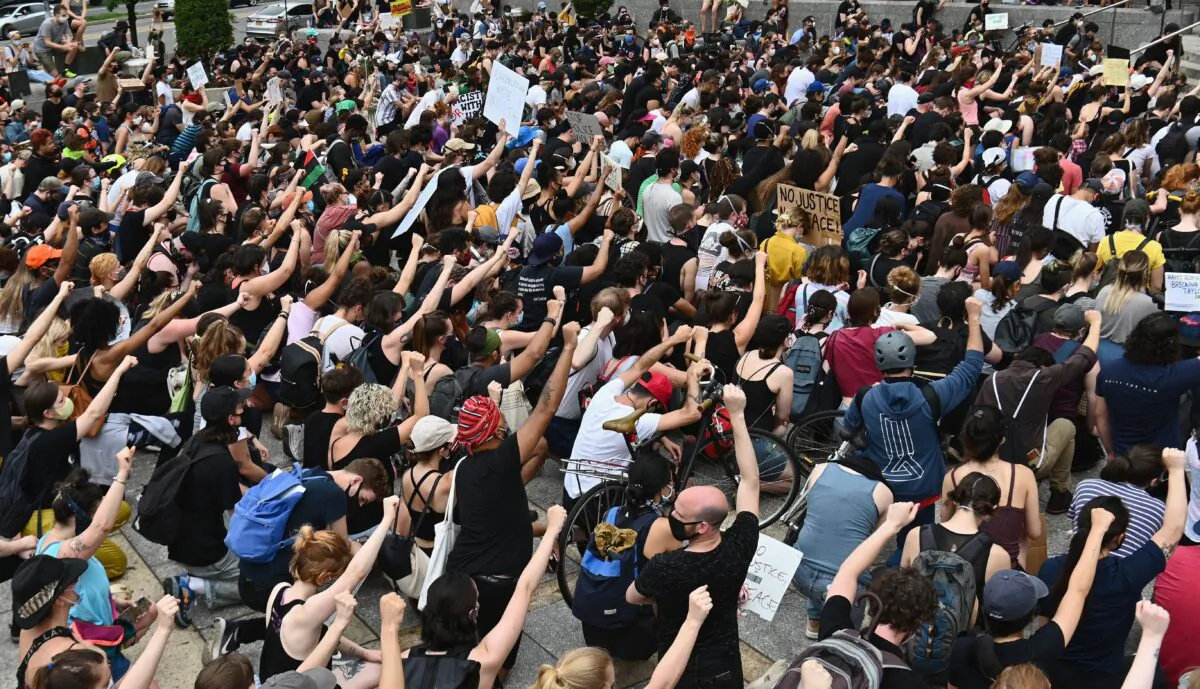 Protesters take a knee and raise their fists during a "Black Lives Matter" demonstration in front of the Brooklyn Library and Grand Army Plaza in Brooklyn, N.Y., on June 5, 2020. (Angela Weiss/AFP via Getty Images)