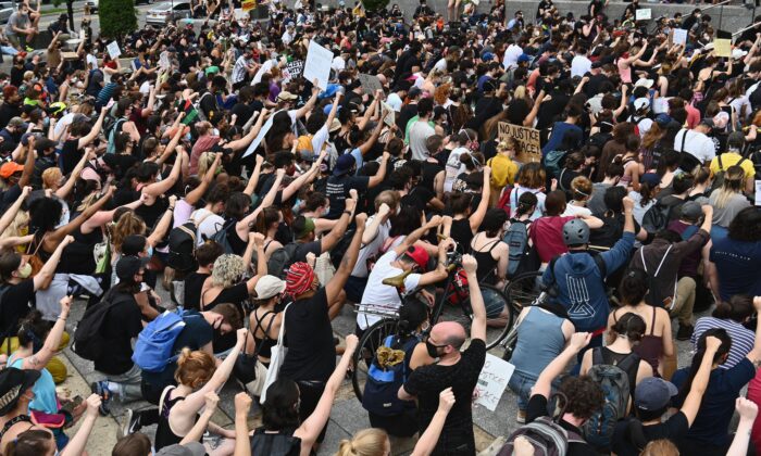 Protesters take a knee and raise their fists during a "Black Lives Matter" demonstration in front of the Brooklyn Library and Grand Army Plaza in Brooklyn, N.Y., on June 5, 2020. (Angela Weiss/AFP via Getty Images)