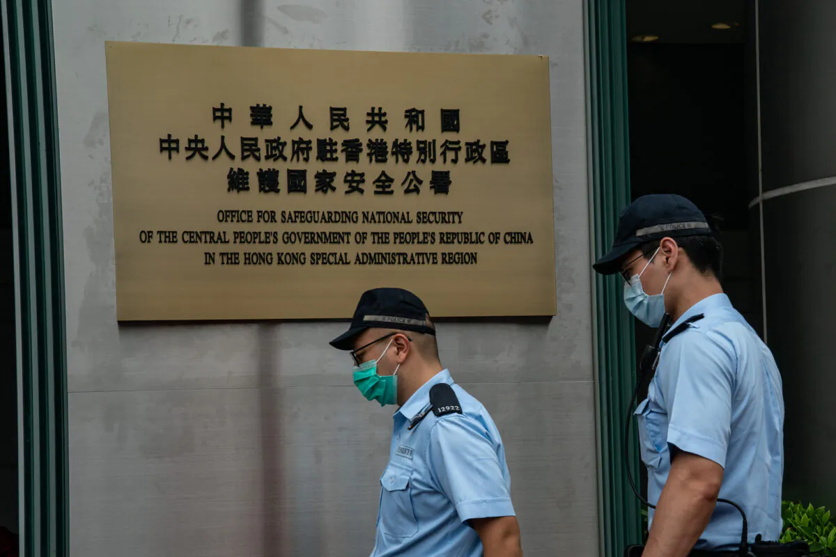 Police officers walk past a plaque outside Beijing's new national security bureau office after its official inauguration in Hong Kong, on July 8, 2020. (Anthony Kwan/Getty Images)
