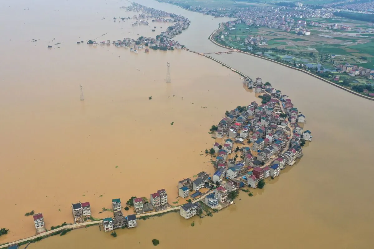 This aerial view shows submerged streets and inundated buildings after a dam was breached due to flooding in Jiujiang, China on July 13, 2020. (STR/AFP via Getty Images)