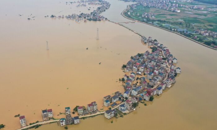 This aerial view shows submerged streets and inundated buildings after a dam was breached due to flooding in Jiujiang, China on July 13, 2020. (STR/AFP via Getty Images)