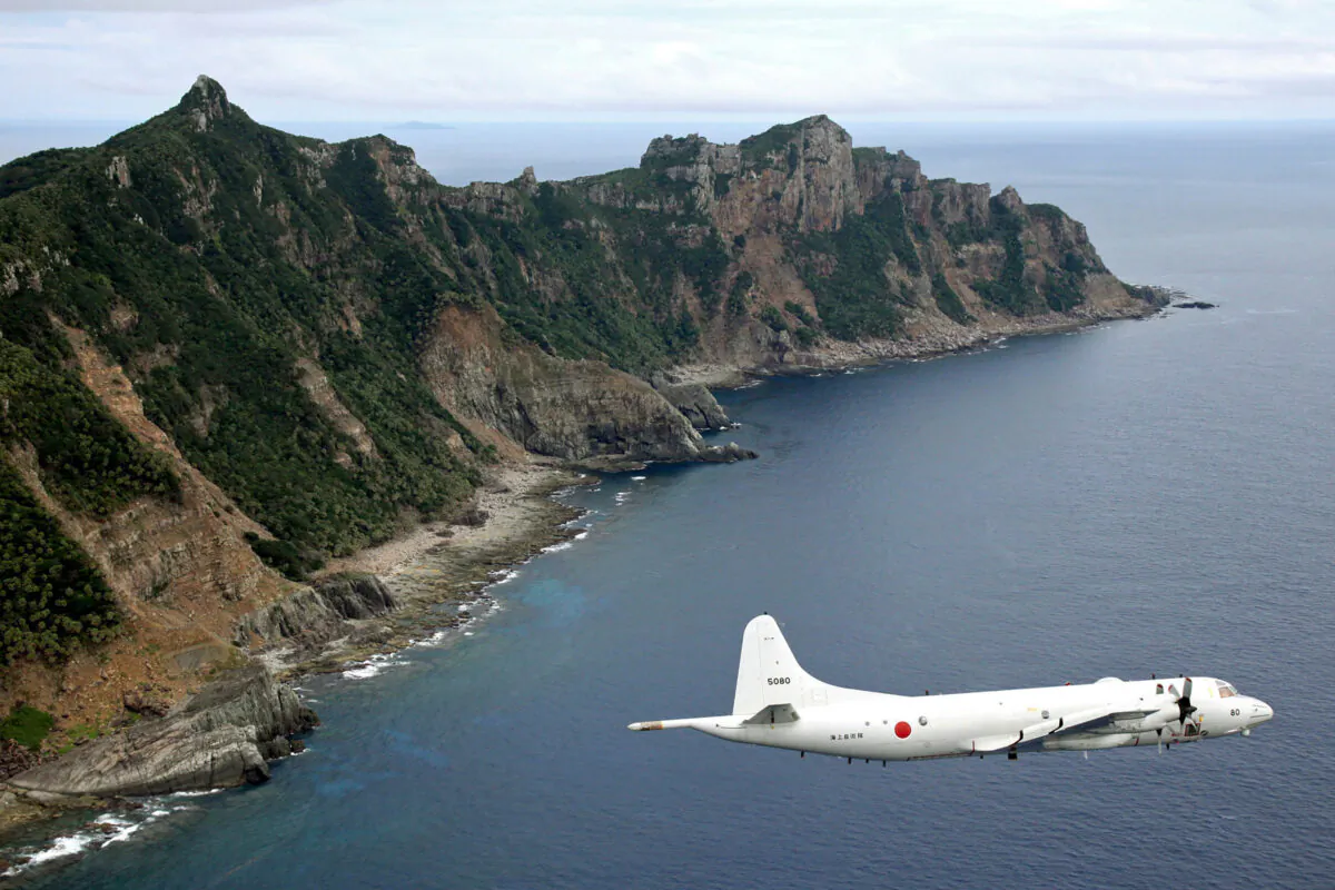 A Japanese Maritime Self-Defense Force P-3C Orion surveillance plane flies over the disputed islands, called the Senkaku in Japan and Diaoyu in China, in the East China Sea, on Oct. 13, 2011. (Kyodo News via AP/File)