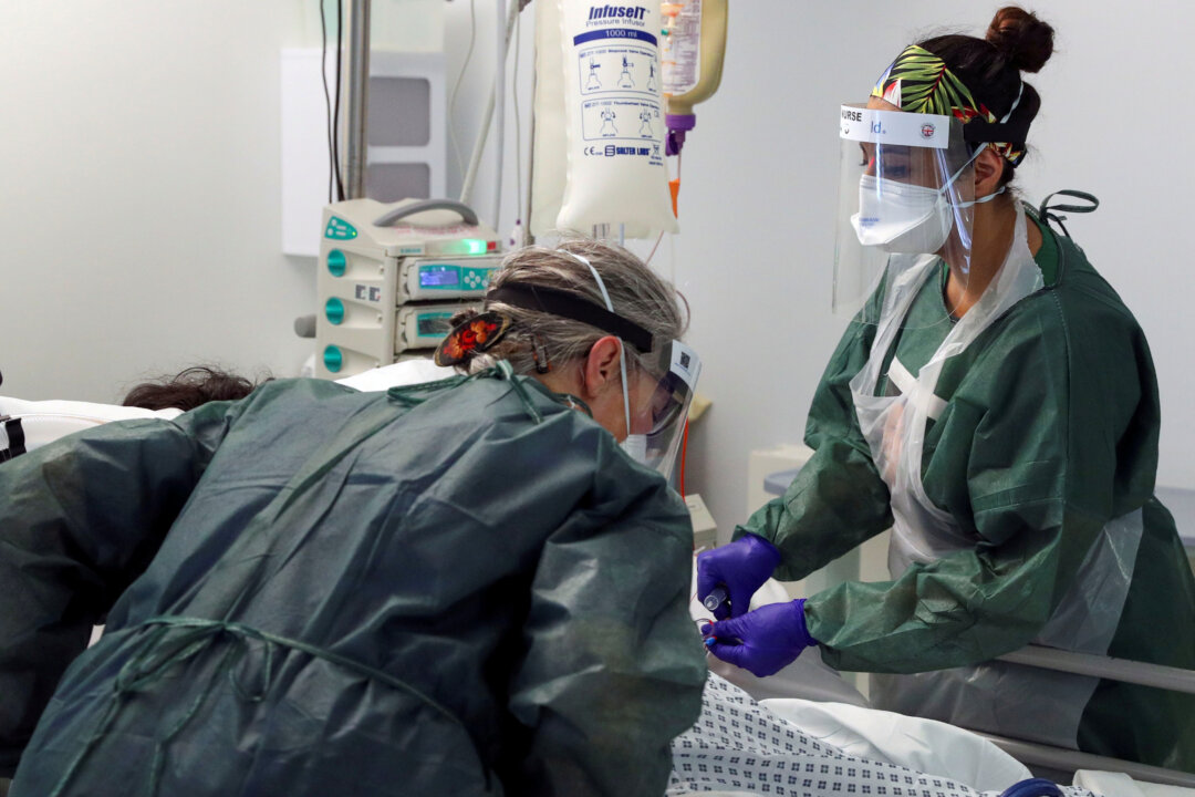 Nurses care for a patient in an Intensive Care ward treating victims of COVID-19 in Frimley Park Hospital in Surrey, England, on May 22, 2020. (Steve Parsons/Reuters)