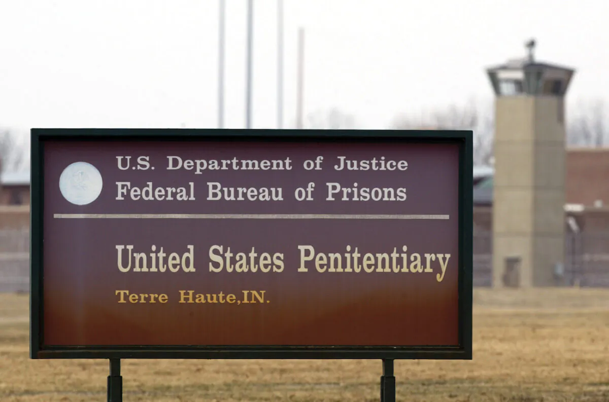A guard tower flanks the sign at the entrance to the U.S. Penitentiary in Terre Haute, Ind., on March 17, 2003. (AP Photo/Michael Conroy File)