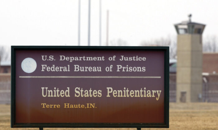 A guard tower flanks the sign at the entrance to the U.S. Penitentiary in Terre Haute, Ind., on March 17, 2003. (AP Photo/Michael Conroy File)