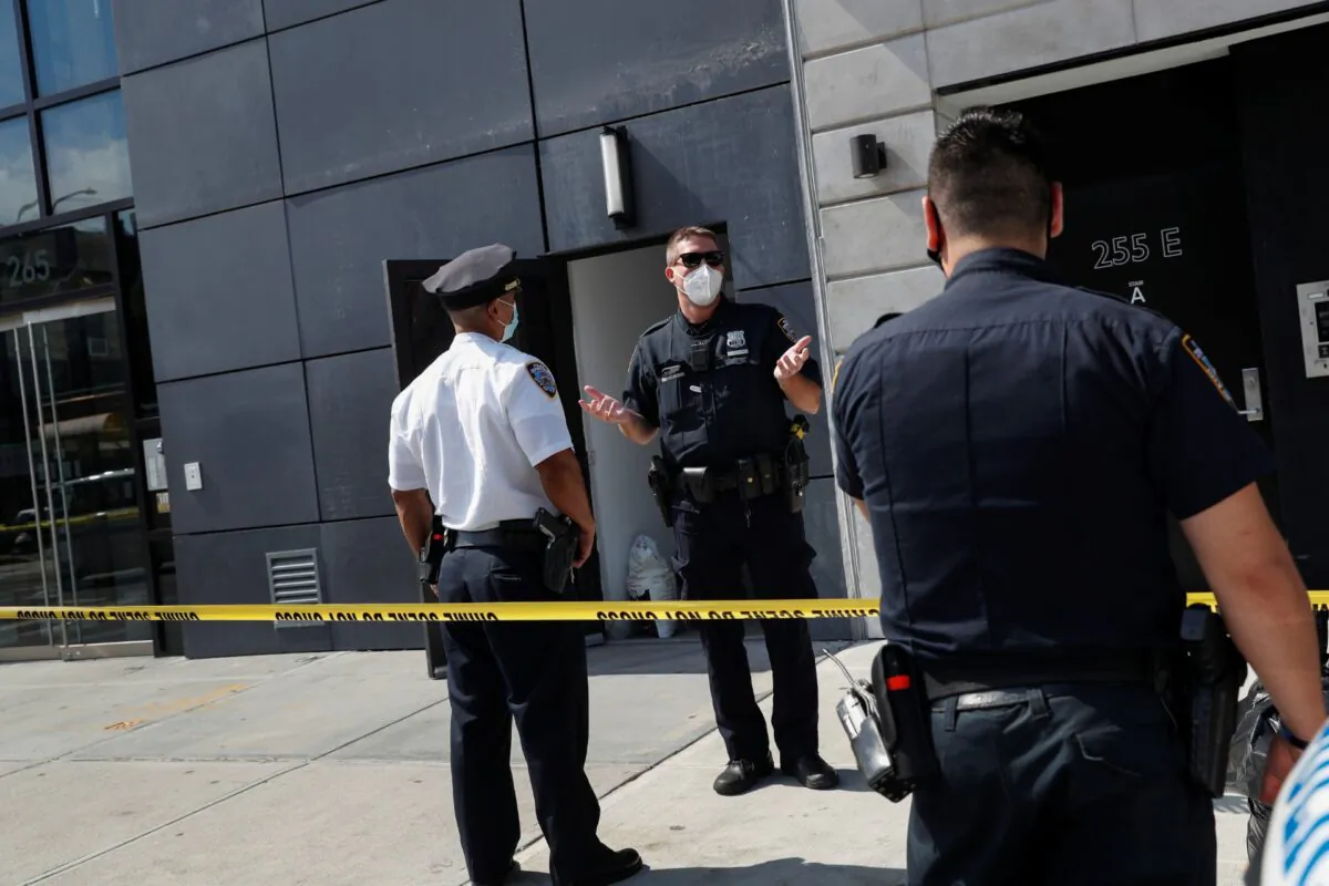 NYPD officers speak at crime scene at 265 Houston Street, where Fahim Saleh, co-founder/CEO of Gokada, was found dead at the apartment building in New York City, N.Y., on July 15, 2020. (Shannon Stapleton/Reuters)