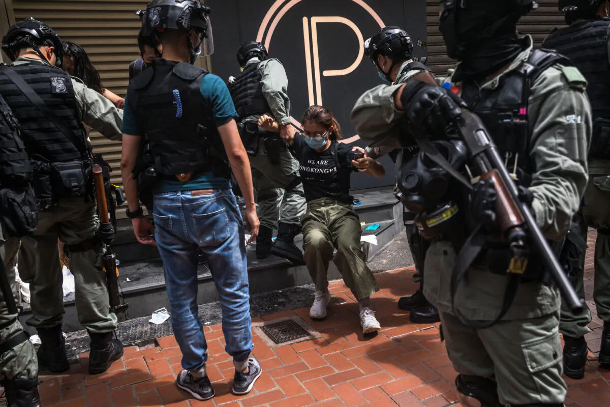 Riot police detain a woman as they clear protesters taking part in a rally against a new national security law in Hong Kong on July 1, 2020, on the 23rd anniversary of the city's handover from Britain to China. (Dale de la Rey/AFP via Getty Images)