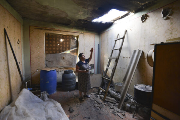 A local woman shows damage in her house-2