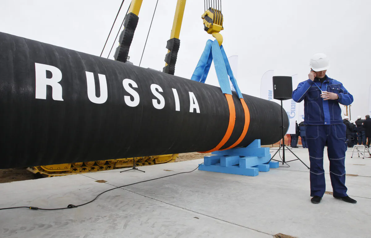 A Russian construction worker speaks on a mobile phone in Portovaya Bay some 106 miles north-west from St. Petersburg, Russia, during a ceremony marking the start of Nord Stream pipeline construction on April 9, 2010. (Dmitry Lovetsky/AP Photo/ file)