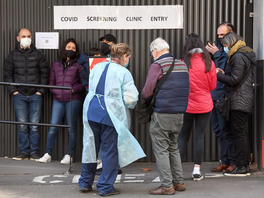 A medical worker (centre L) speaks to people queueing outside a COVID-19 testing venue at The Royal Melbourne Hospital in Melbourne on July 16, 2020. (WILLIAM WEST/AFP via Getty Images)