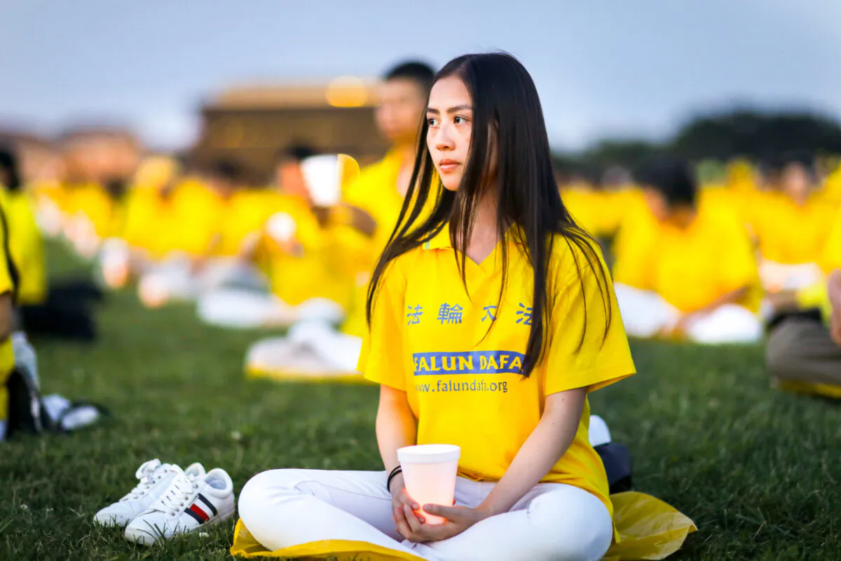 Falun Gong practitioners take part in a candlelight vigil commemorating the 20th anniversary of the persecution of Falun Gong in China on the West Lawn of Capitol Hill on July 18, 2019. (Samira Bouaou/The Epoch Times)