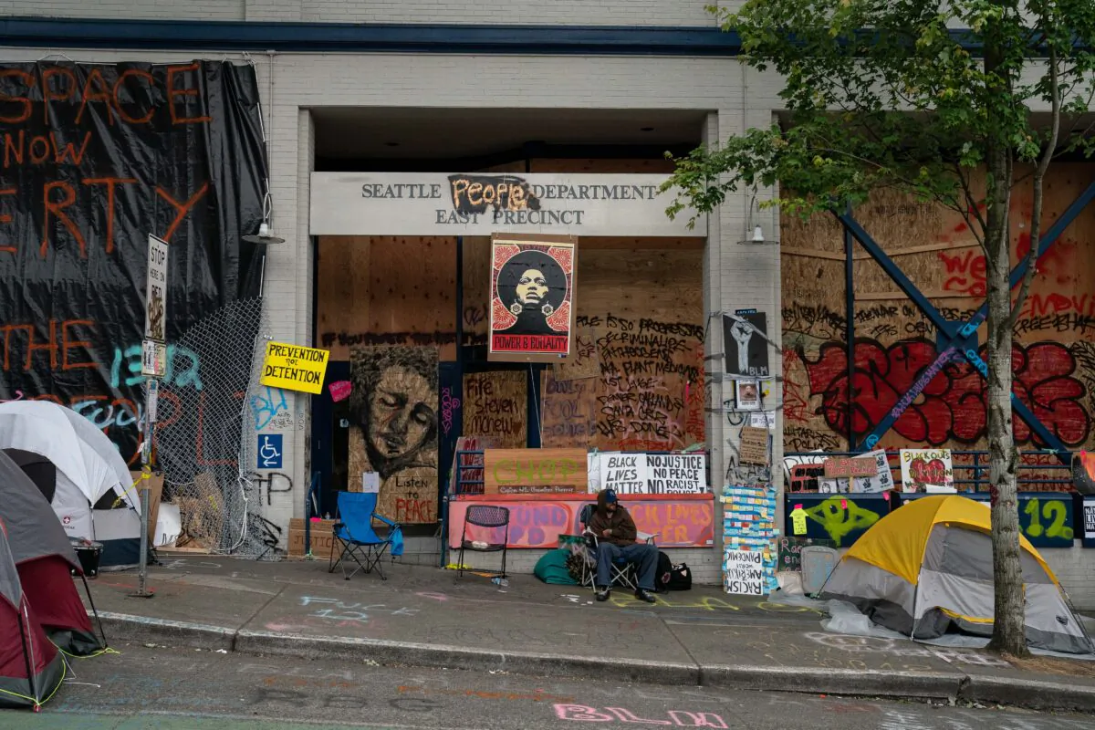 A man sits outside of the Seattle Police Department's vacated East Precinct in the area known as the Capitol Hill Organized Protest (CHOP) in Seattle on June 26, 2020. (David Ryder/Getty Images)