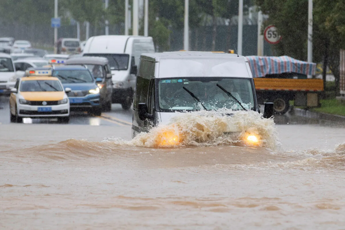 A vehicle travels through a flooded section of a road following heavy rainfall in Wuhan, Hubei province, China, on July 6, 2020. (China Daily via Reuters/File Photo)