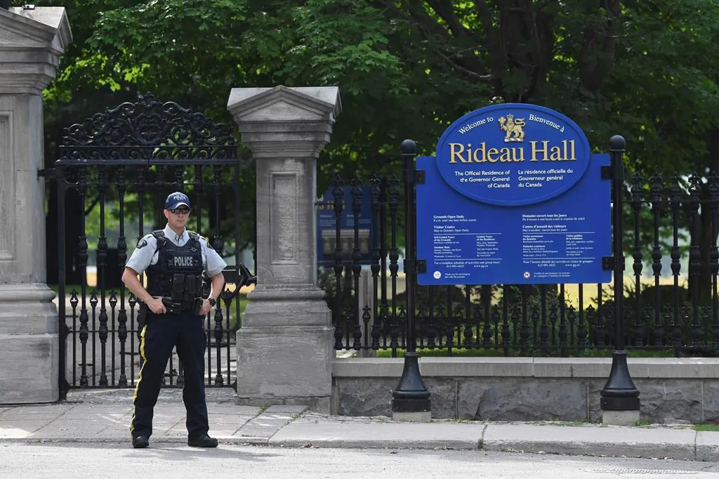 A security guard stands outside Rideau Hall where Canada's prime minister and governor general normally live. (The Canadian Press)