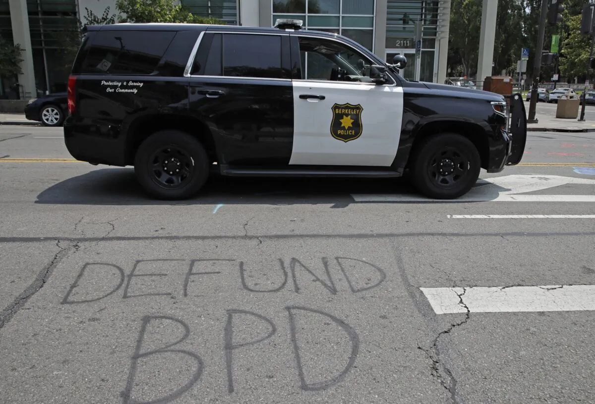 A Berkeley police vehicle waits at a stop light near graffiti calling for the defunding of the Berkeley police department in Berkeley, Calif., on July 15, 2020. (Ben Margot/AP Photo)