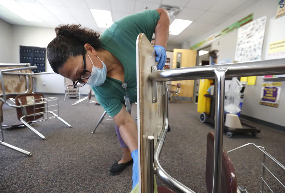 A person cleans a classroom at Wylie High School, in Wylie, Texas, on July 14, 2020. (AP Photo/LM Otero)