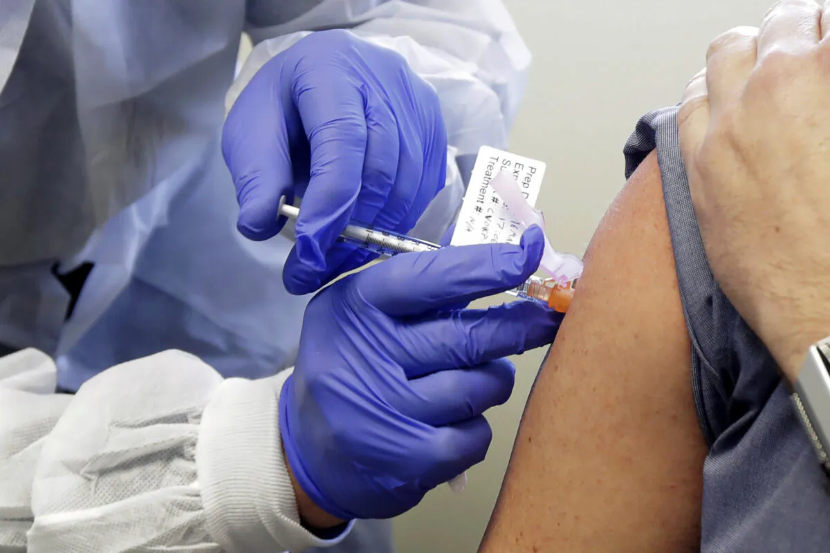 A subject receives a shot in the first-stage safety study clinical trial of a potential vaccine by Moderna for COVID-19, the disease caused by the new coronavirus, at the Kaiser Permanente Washington Health Research Institute in Seattle, on March 16, 2020. Britain, the United States and Canada accused Russia on July 16, 2020, of trying to steal information from researchers seeking a COVID-19 vaccine. (Ted S. Warren/AP Photo)