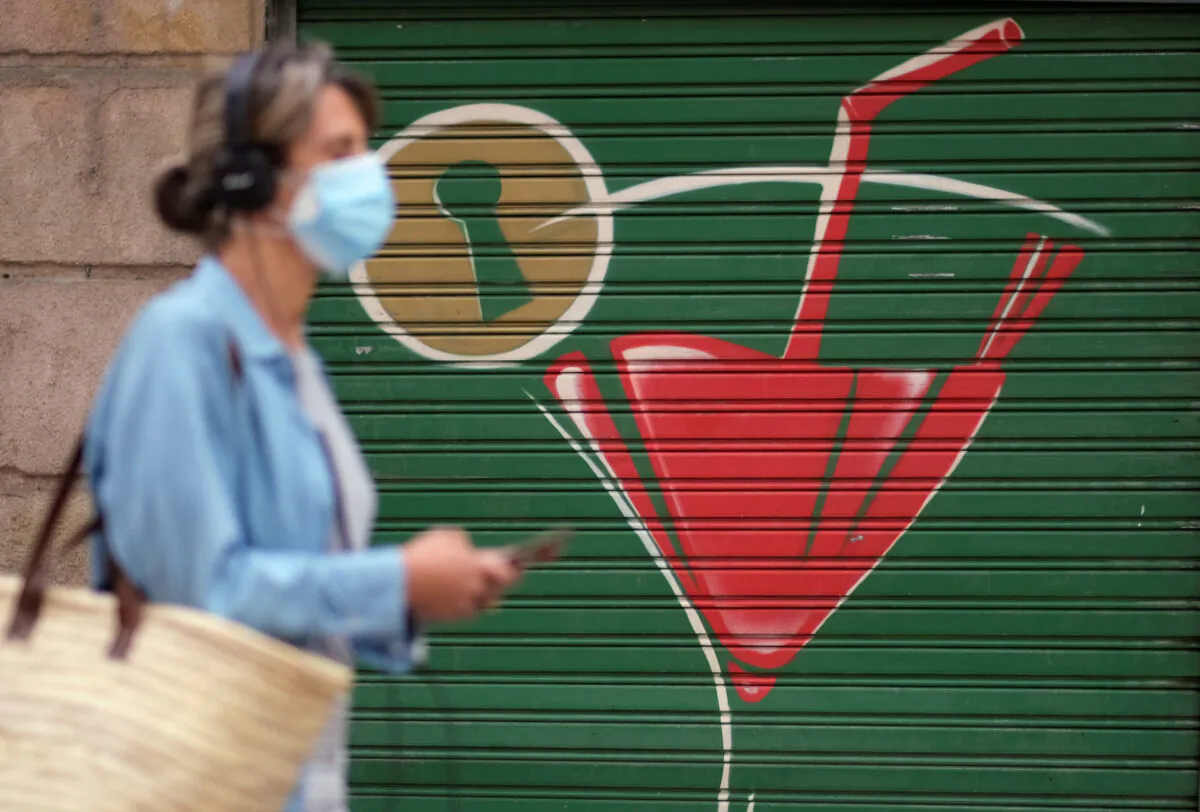 A woman wearing a face mask walks on a street, after Catalonia's regional authorities and the city council announced restrictions to contain the spread of the coronavirus disease (COVID-19) in Barcelona, Spain, on July 17, 2020. (Nacho Doce/Reuters)