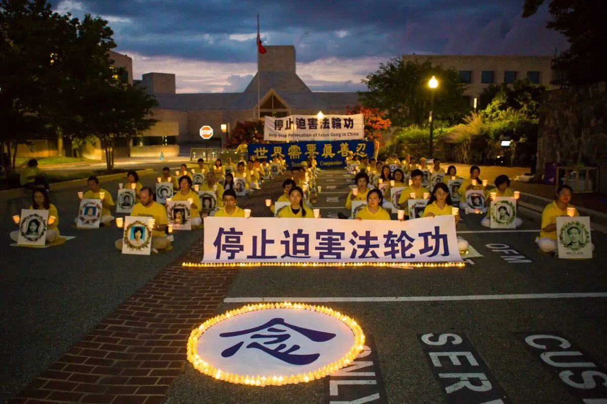Falun Gong practitioners hold a candlelight vigil outside the Chinese Embassy in Washington on July 17, 2020. The Chinese character in the foreground is "memorial." The sign held by those in the front row says, "Stop the Persecution of Falun Gong." (Lisa Fan/The Epoch Times)