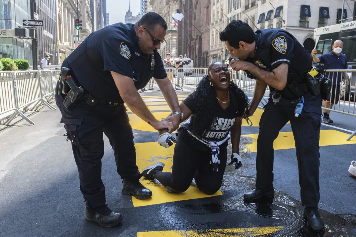 New York Police Department officers attempt to detain a protester who defaced with black paint the Black Lives Matter mural outside of Trump Tower on Fifth Avenue in Manhattan on July 18, 2020. (Yuki Iwamura/AP Photo)