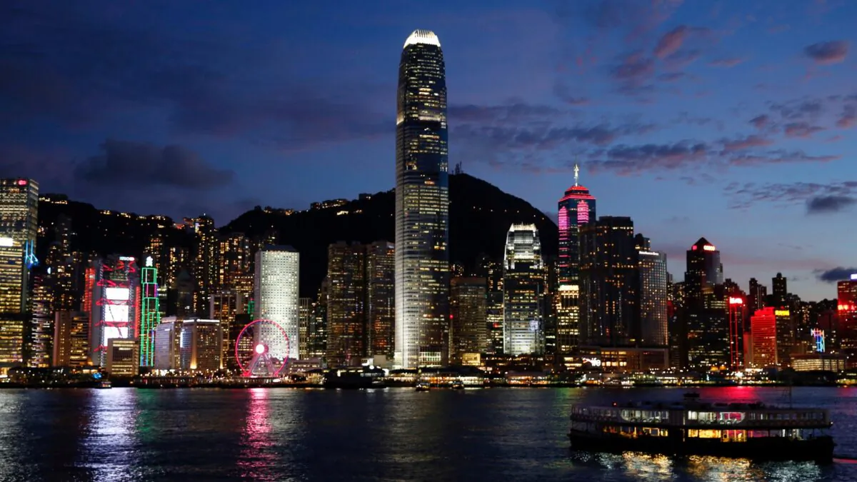 A Star Ferry boat crosses Victoria Harbor in front of a skyline of buildings during sunset, as a meeting on national security legislation takes place in Hong Kong, on June 29, 2020. (Tyrone Siu/Reuters)