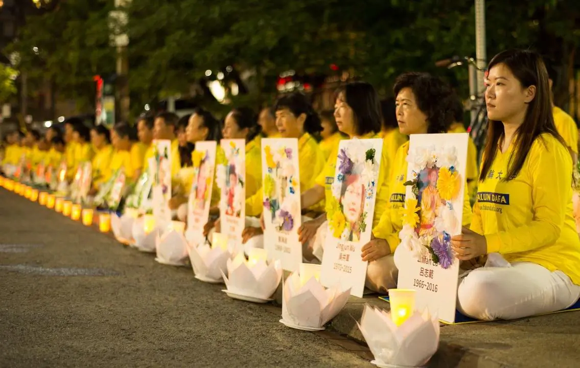 Falun Gong practitioners hold a candlelight vigil in front of the Chinese Consulate in Toronto on July 13, 2019, holding photos of fellow adherents who had died as a result of persecution in China. (Handout)