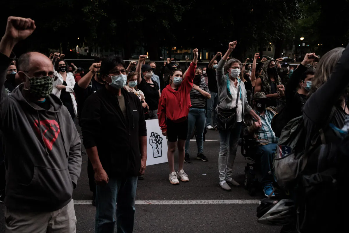 Demonstrators raise their hands up in solidarity at Multnomah County Justice Center in Portland, Ore., on July 17, 2020. (Mason Trinca/Getty Images)