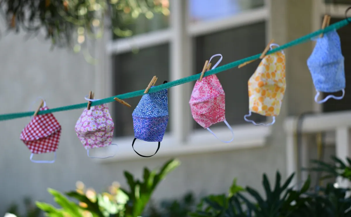 For sale masks are seen displayed on a clothesline in the front yard of a house in Los Angeles on July 20, 2020. (Chris Delmas/AFP via Getty Images)