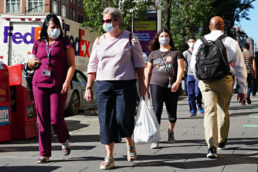 People walk while wearing protective masks as New York City moves into Phase 3 of reopening following restrictions imposed to curb the CCP virus pandemic, on July 14, 2020. (Cindy Ord/Getty Images)